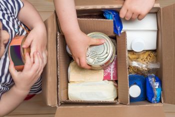 Children-opening-a-food-delivery-box-at-home,-online-ordering.-Grocery-stor