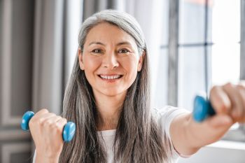 Sporty-caucasian-mature-grey-haired-woman-during-fitness-with-dumbbells,-cl