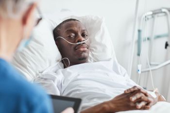 African-Man-with-Oxygen-Support-in-Hospital-Room-1312641893_2125x1416