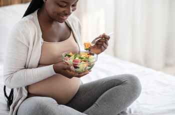 Black-Pregnant-Woman-Holding-Bowl-With-Fresh-Vegetable-Salad,-Enjoying-Heal