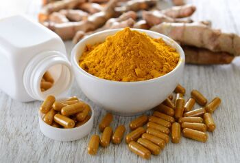 Turmeric-powder-and-turmeric-capsules-on-wooden-background-842247612_1248x8