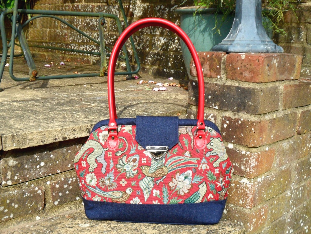 Red tapestry fabric handbag with leather handles