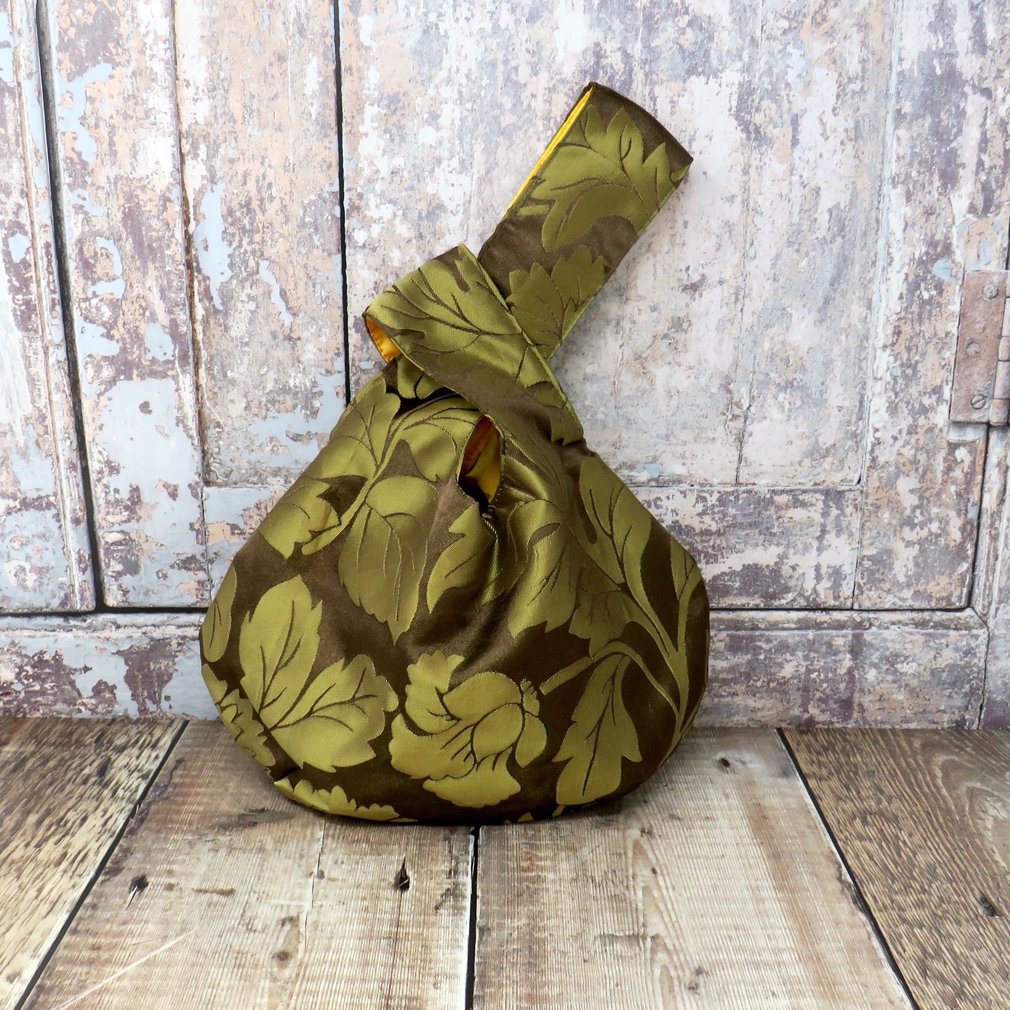 A beautiful handmade clutch in a pink and green leaf print.