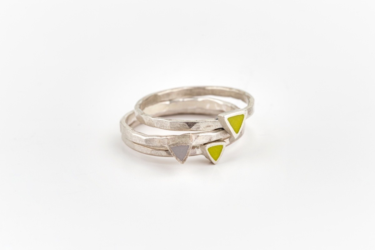 A stack of three rings made from recycled sterling silver with triangle settings in yellow and grey 