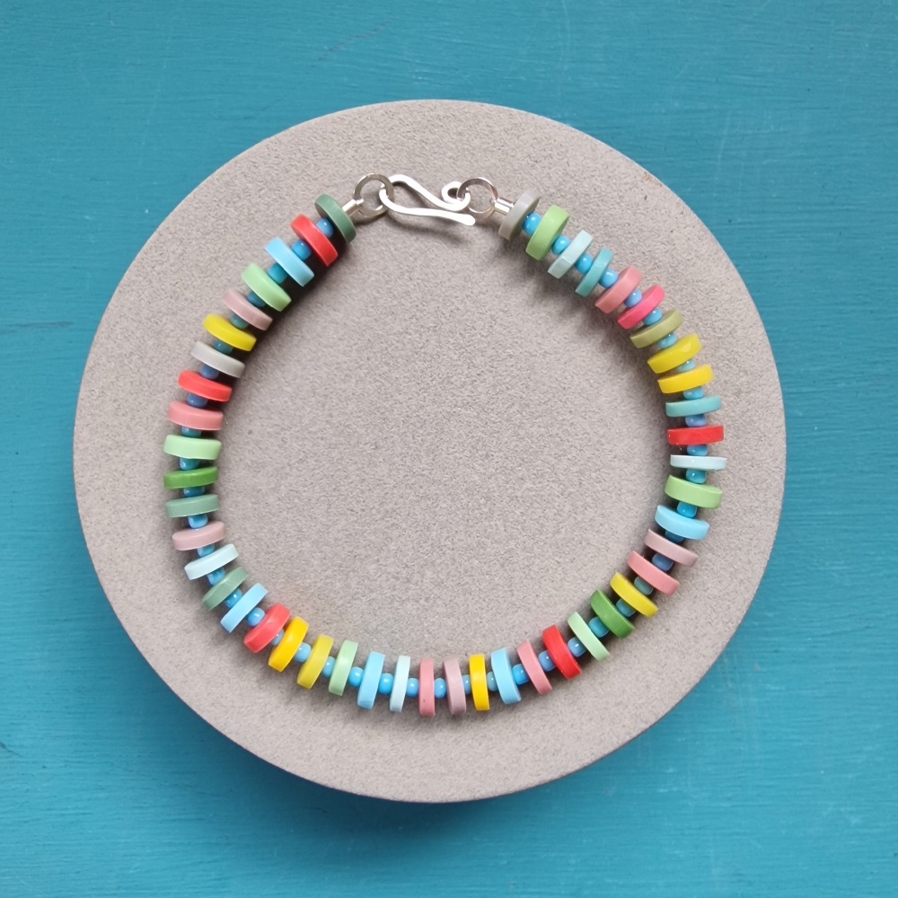 Bracelet with tiny disc beads in yellow, red, pale green, pale blue and dusky pink