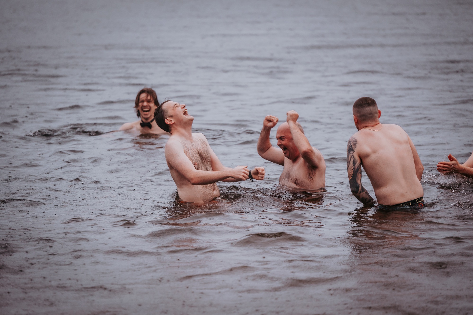Bride and friends taking an early morning wild swim in the Lake District before the wedding ceremony.