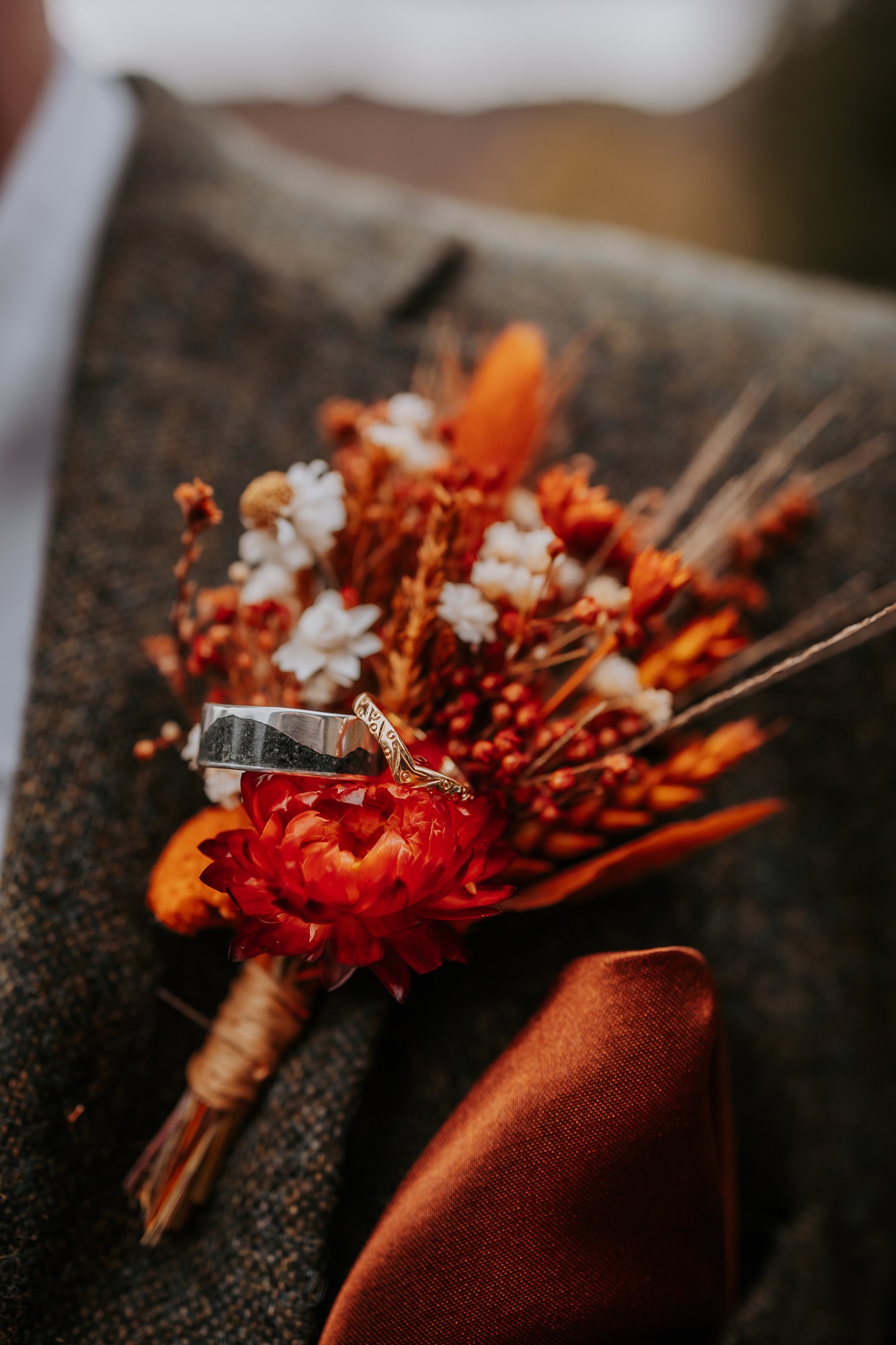 Close-up of the brideâ€™s autumnal bouquet featuring dried flowers, pinecones, and rust-coloured foliage.