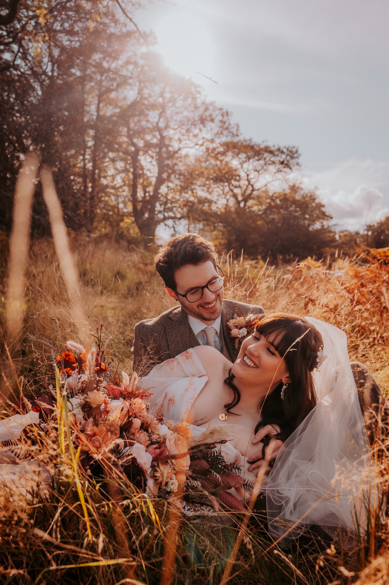 Bride and Groom in long grasses, with Autumnal colours - The Wild Boar, Windermere, Lake District