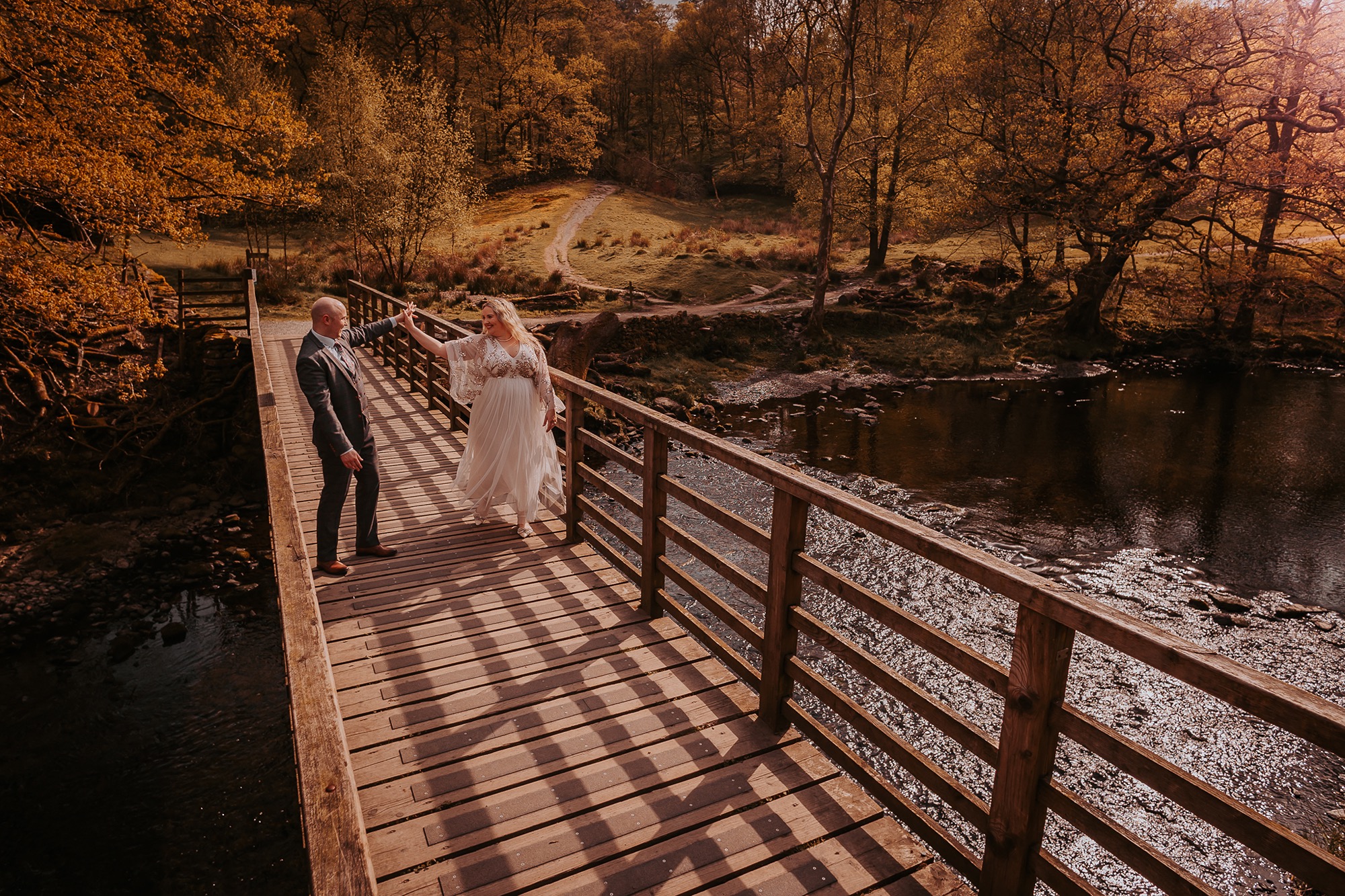 Couple dance on bridge at Rydal water for fun wedding photographs