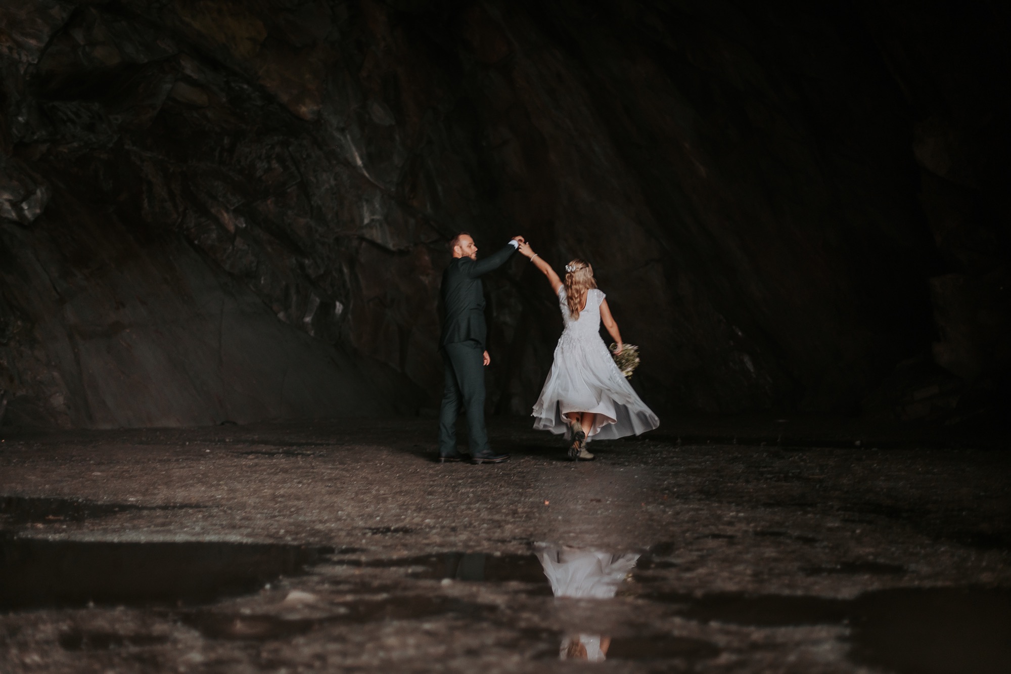 Bride twirls and dances in Rydal cave with husband after eloping at Rydal Cave