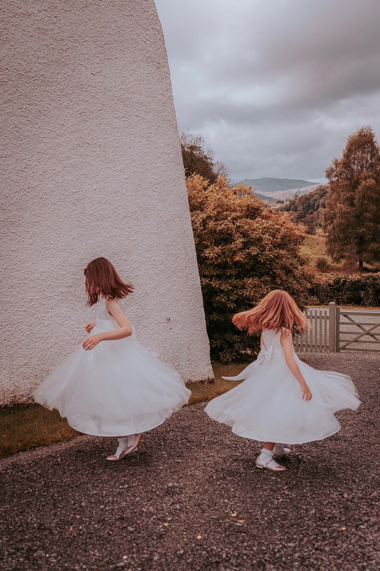 two flowergirls twirling onside Cote How, Ambleside 