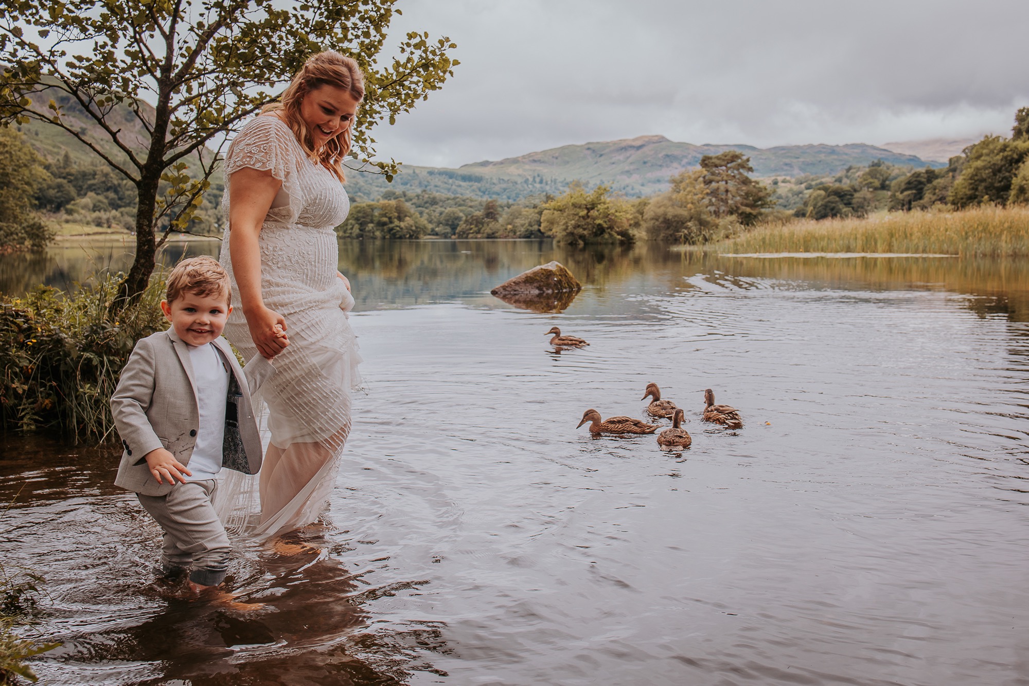 Bride and son paddle in Rydal water after family elopement at Cote How in the Lake District