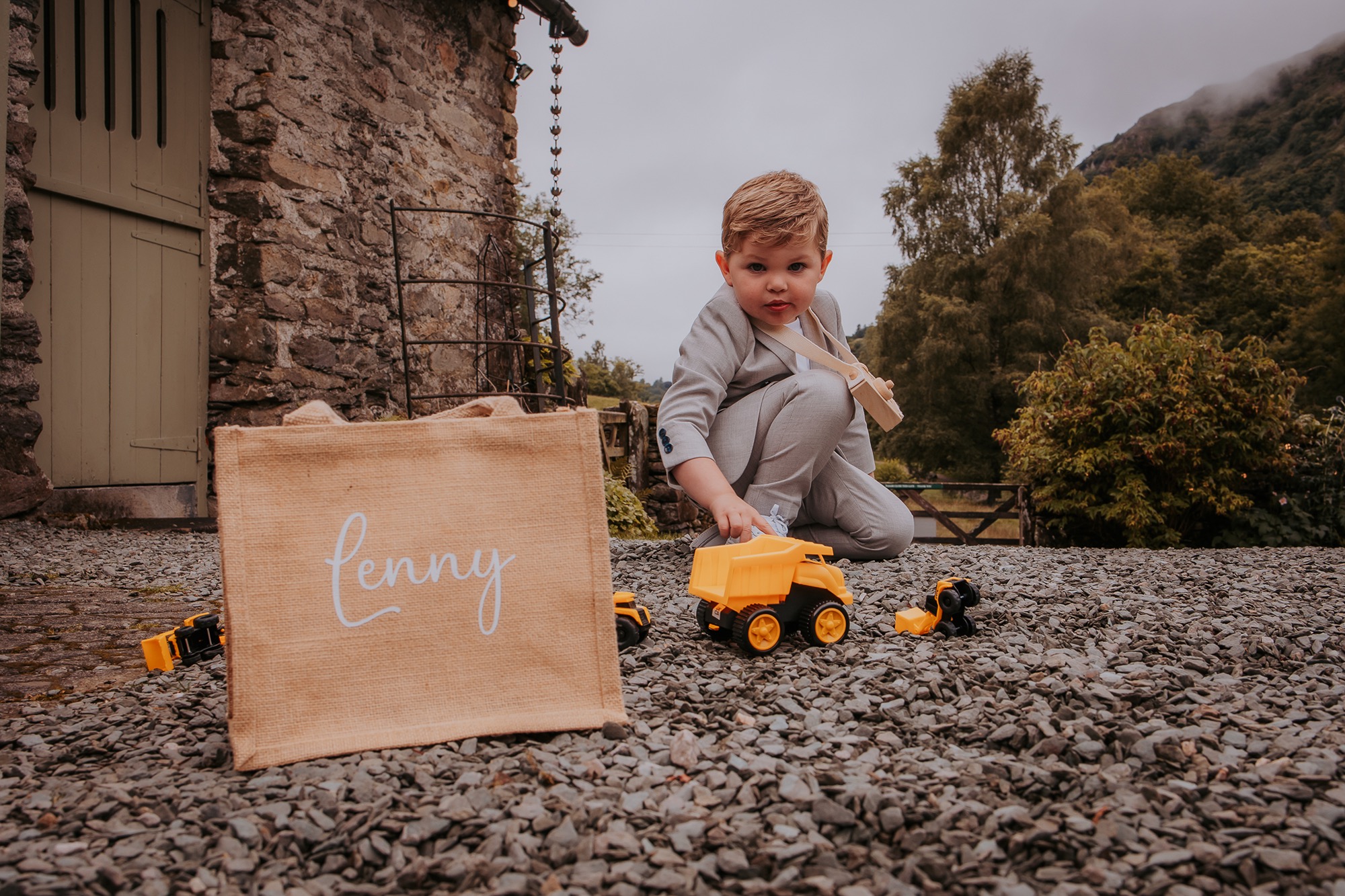 little boy plays with toy diggers as his parents elope at Cote How in the Lakes District