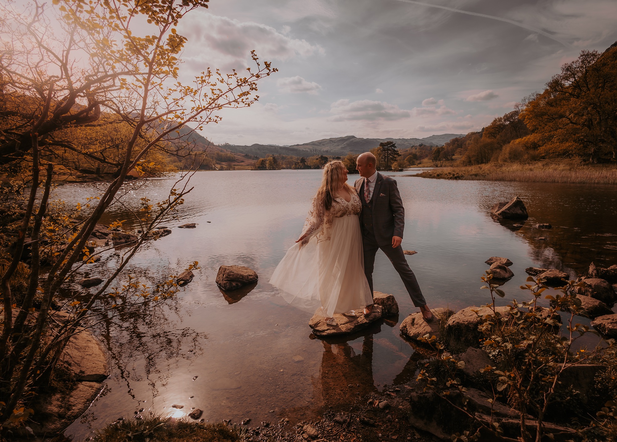 couple enjoy a kiss on stepping stones at Rydal water