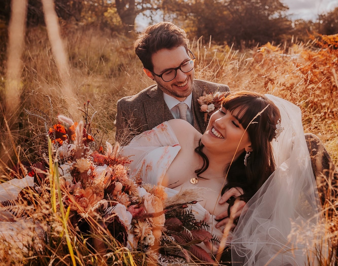 Bride and Groom in long grasses, with Autumnal colours - The Wild Boar, Windermere, Lake District