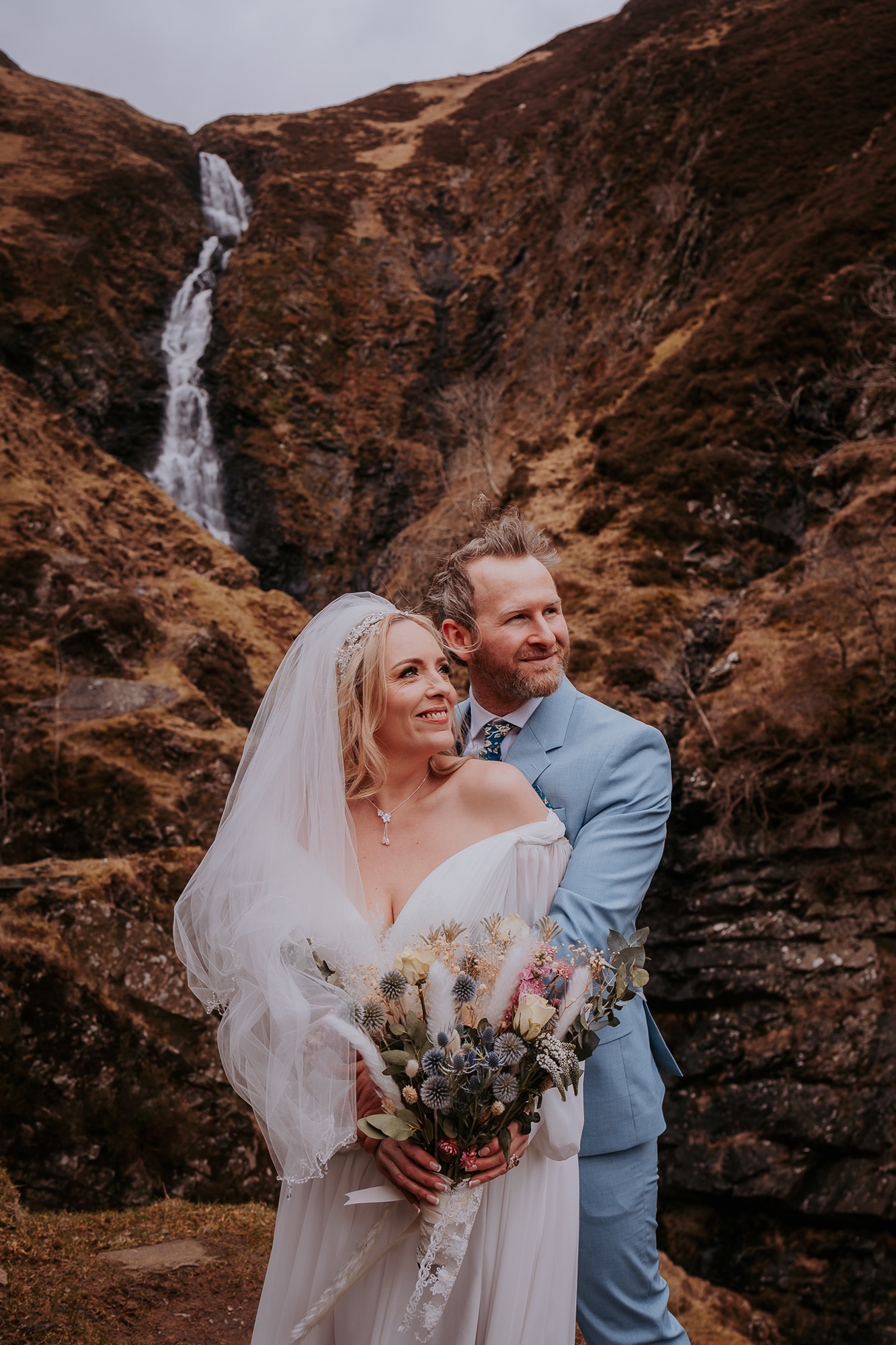bride and groom embrace at grey mares tail, Scotland