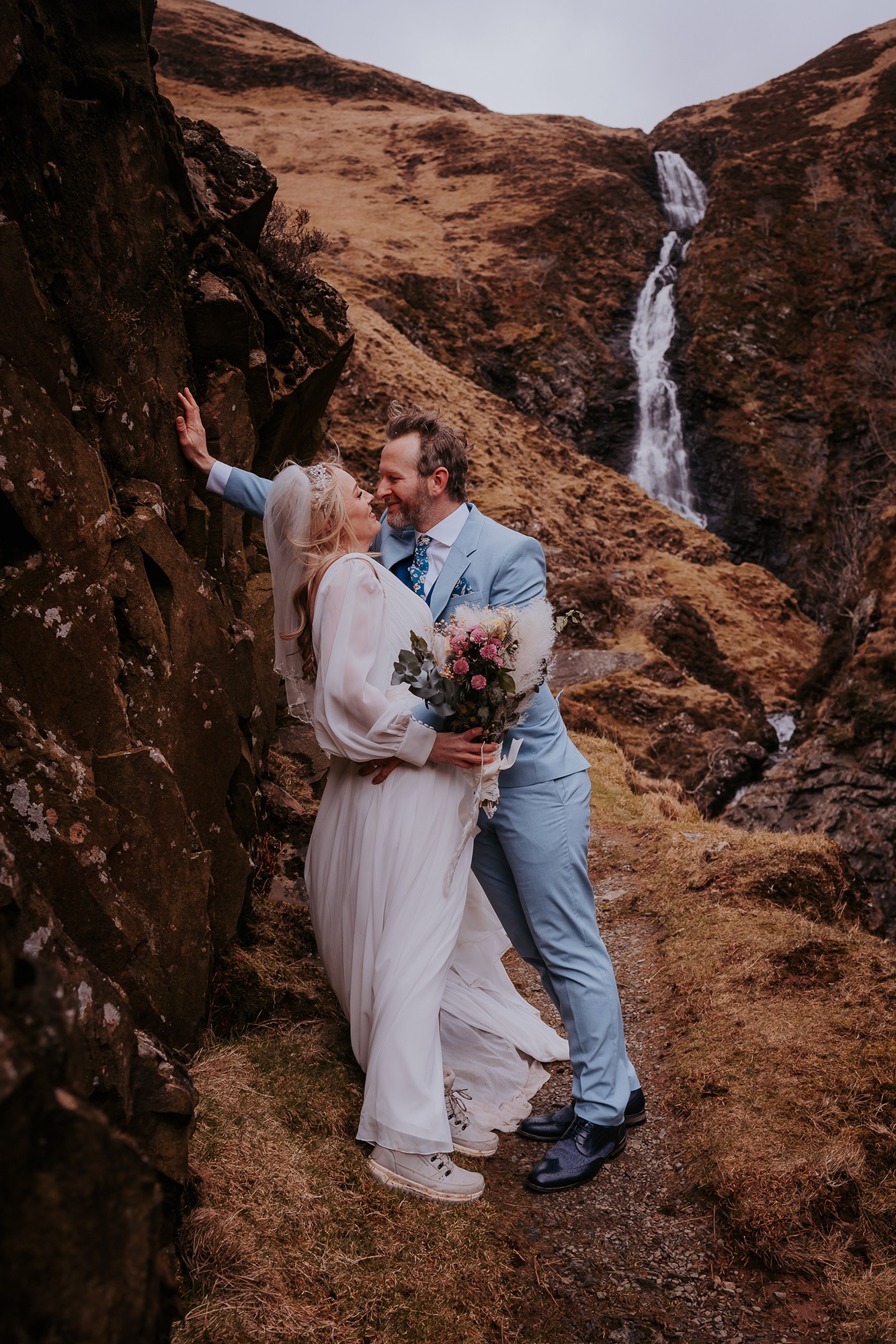 wedding couple kiss under grey mares tail