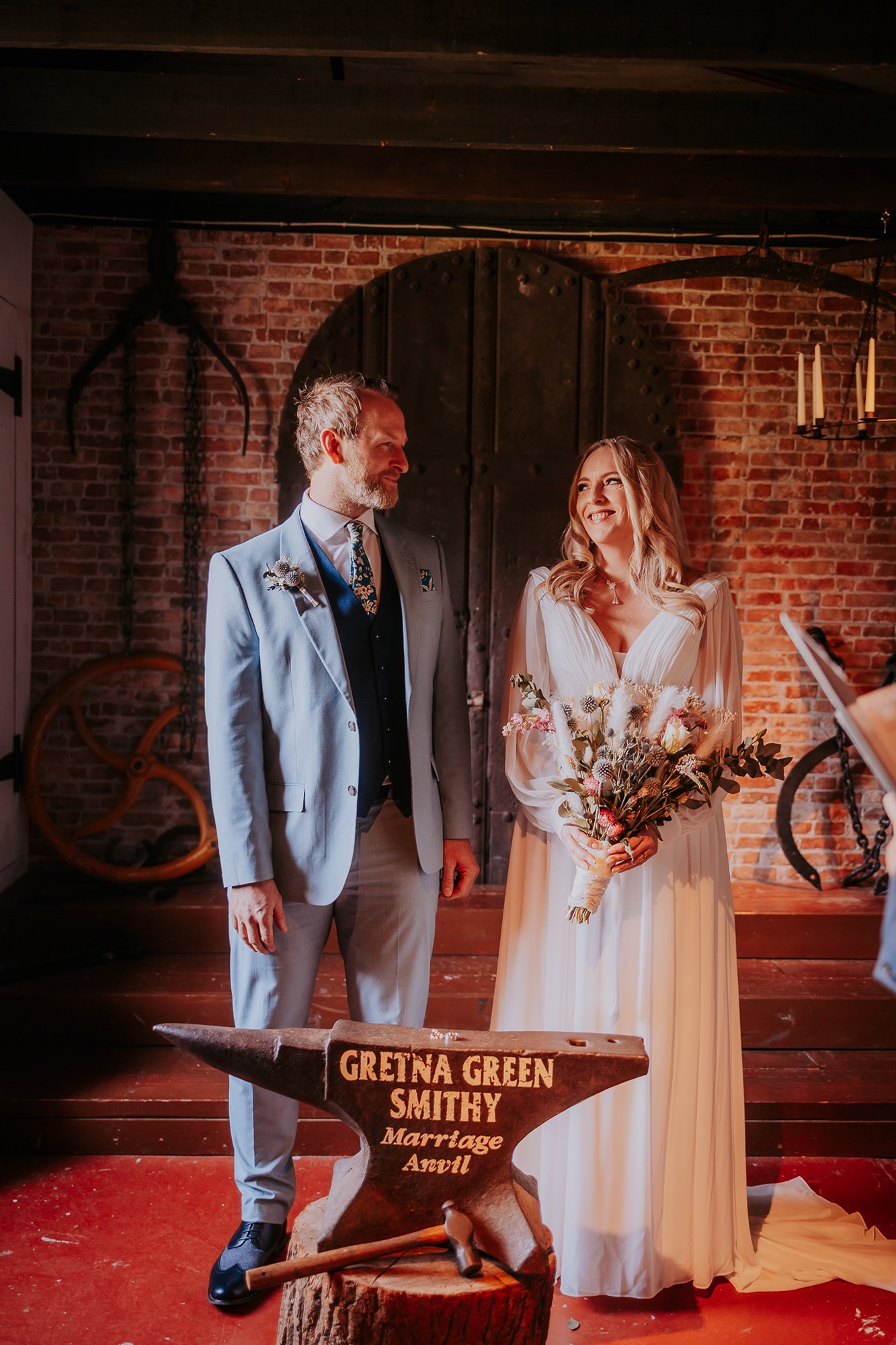 couple get married at Gretna Green in front on marriage Anvil