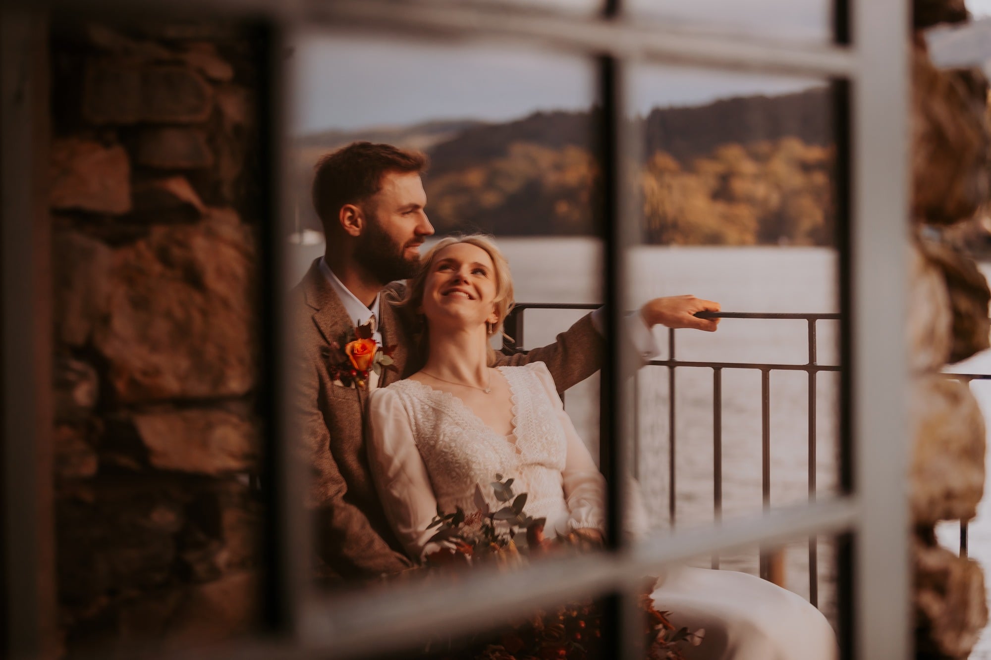 Reflection of bride and groom enjoying a moment on the balcony at the boat house, Town Head Estate