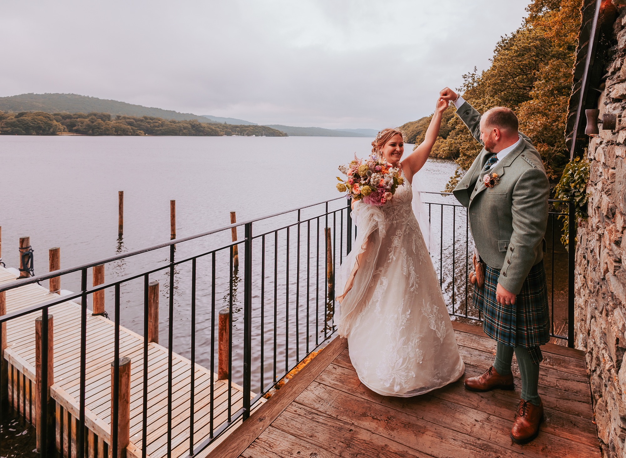 Bride and groom dance on balcony of Town Head Estates boat house