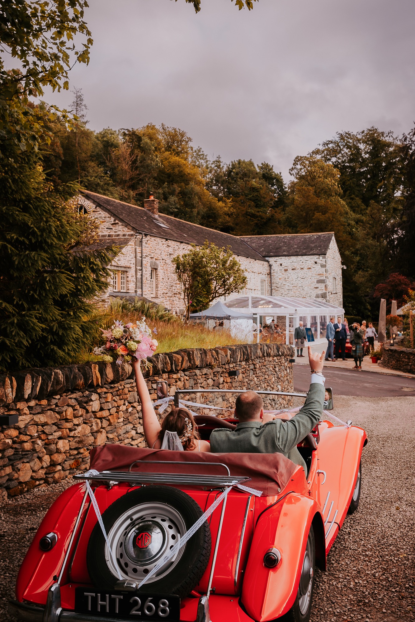 Couple arriving at Town Head Estate in red vintage car