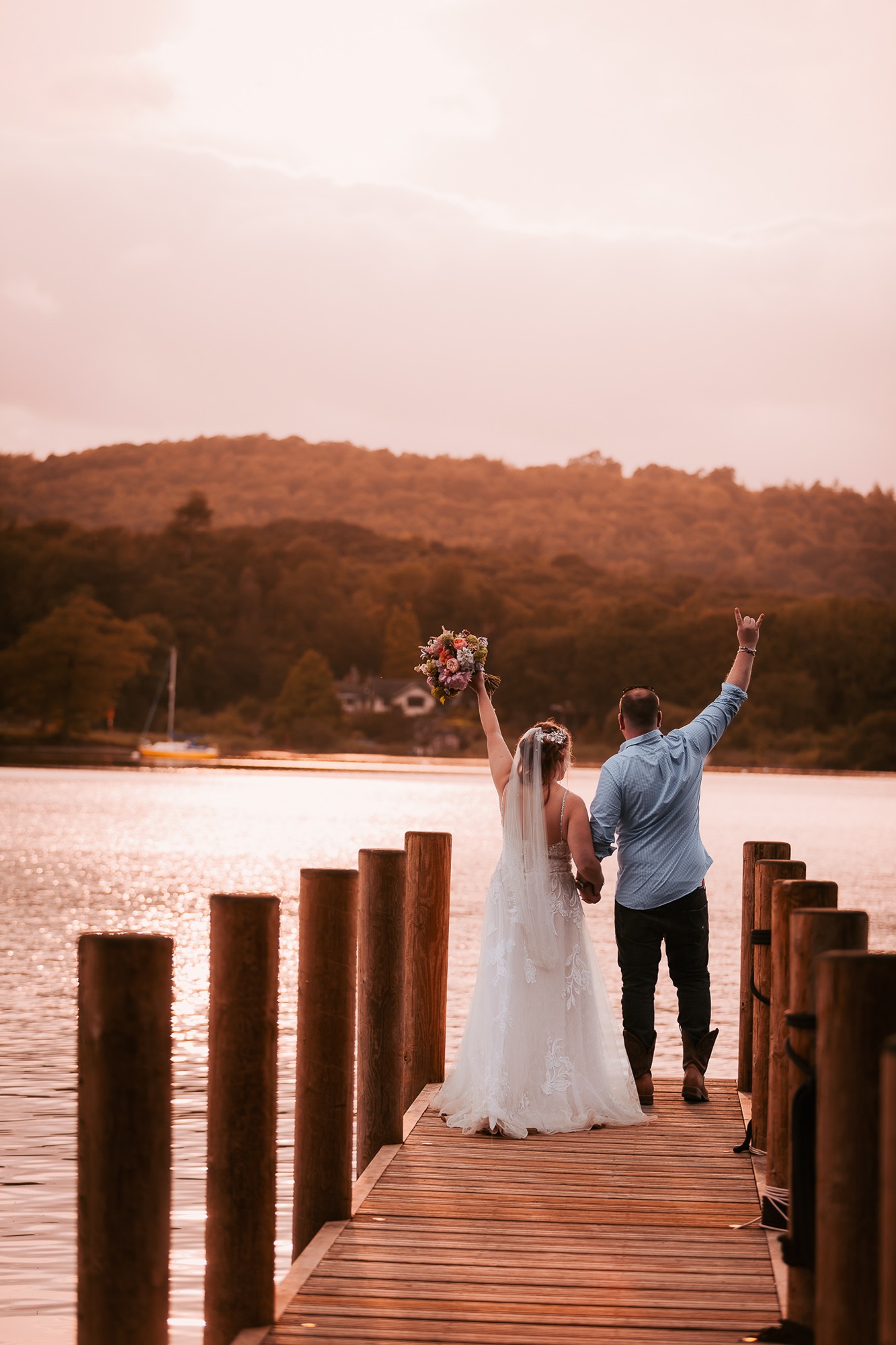 Bride and Groom enjoying golden hour on jetty onto Windermere at Town Head Estate