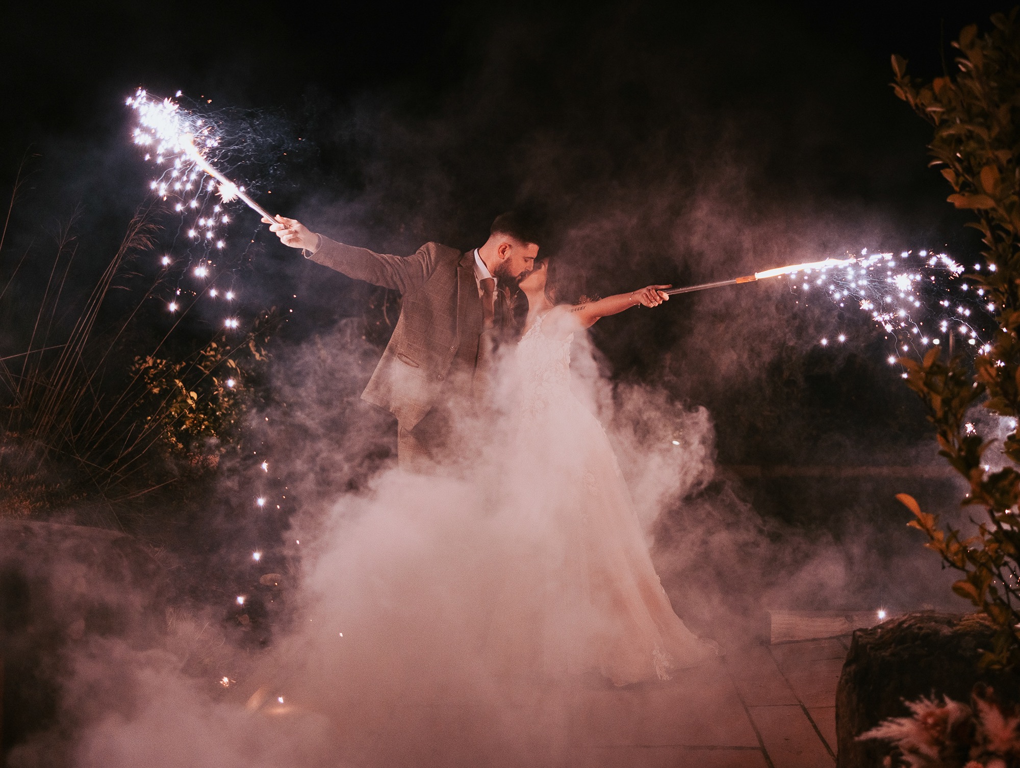 Bride and Groom celebrate wedding with handheld sparkler flares at Eden Wedding Barn