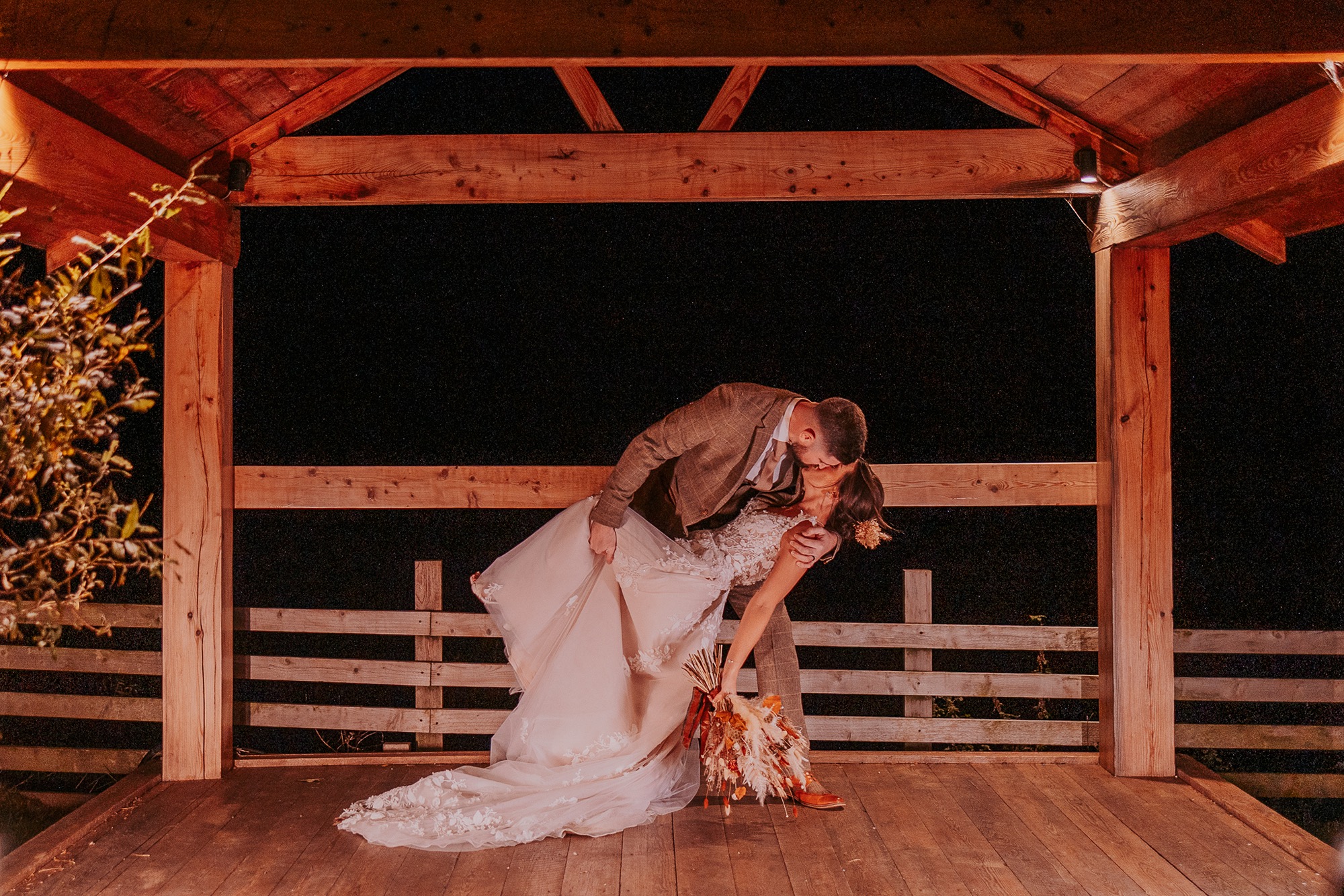 Bride and Groom enjoy romantic dip during a night portrait at Eden Wedding Barn