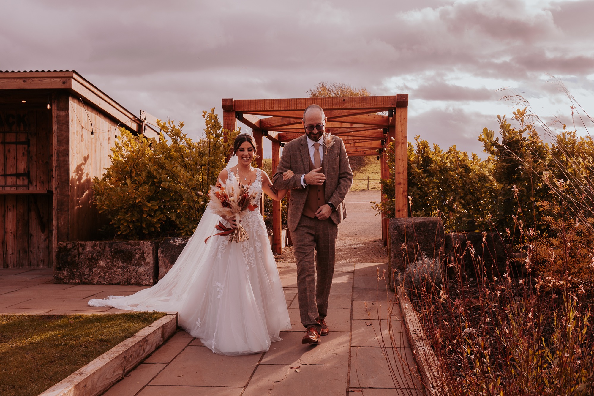 father of the bride walking the bride to her wedding ceremony at Eden Wedding Barn
