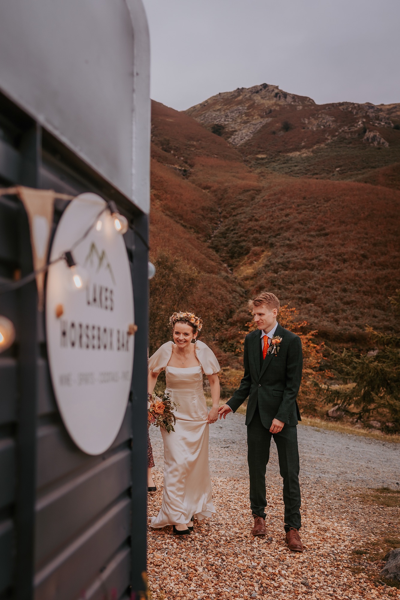 Newly-weds holding hands on a mountain side walk