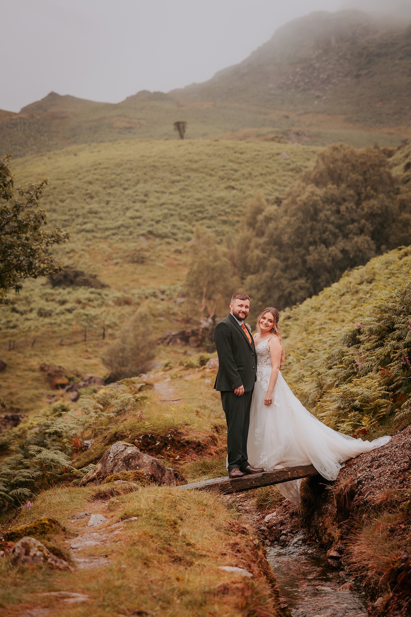Gental pose for bride and groom on a small wooden bridge