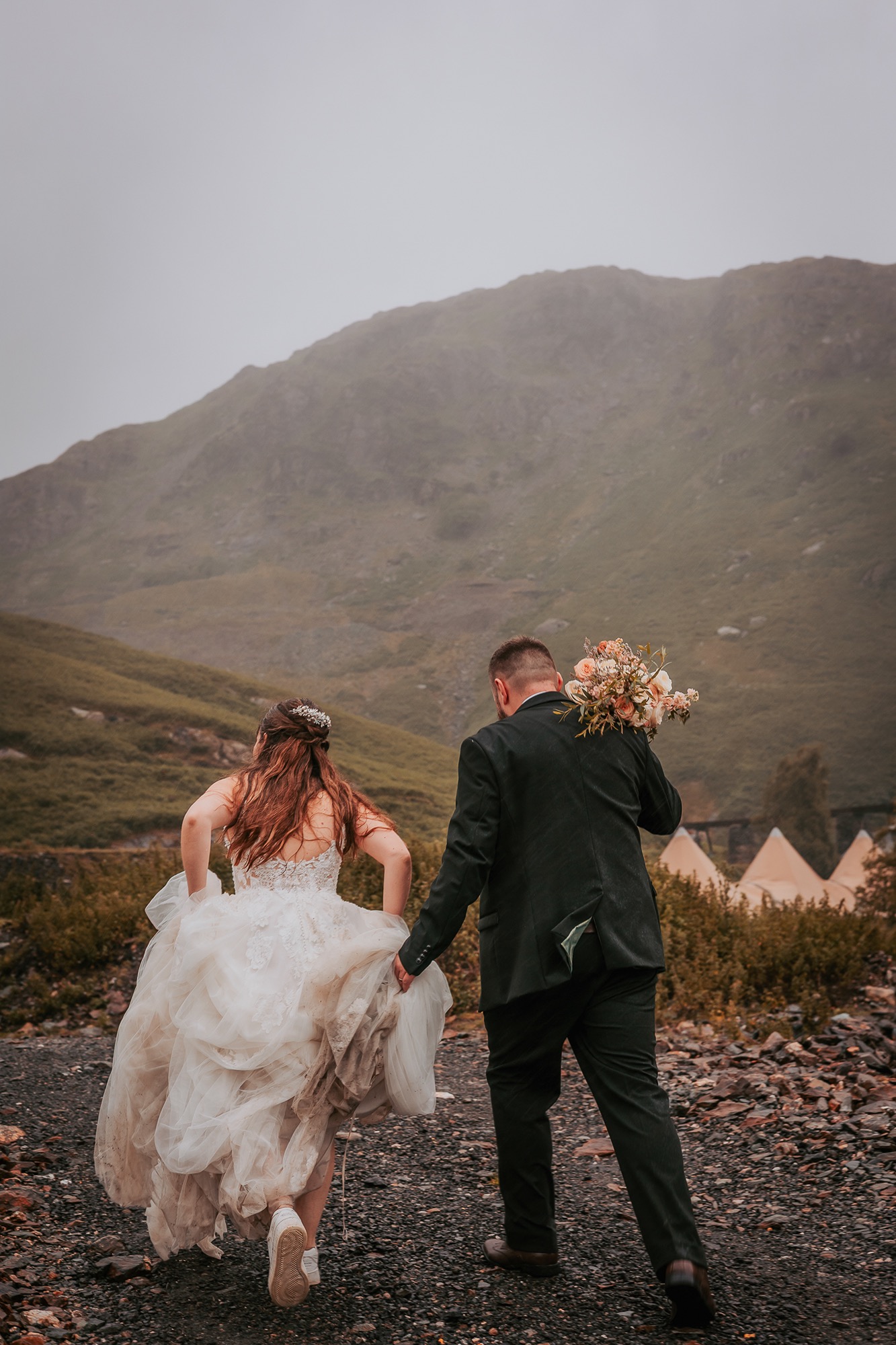 Bride and Groom embrace the stormy weather on their wedding day at Coniston Coppermines Mountain weddings