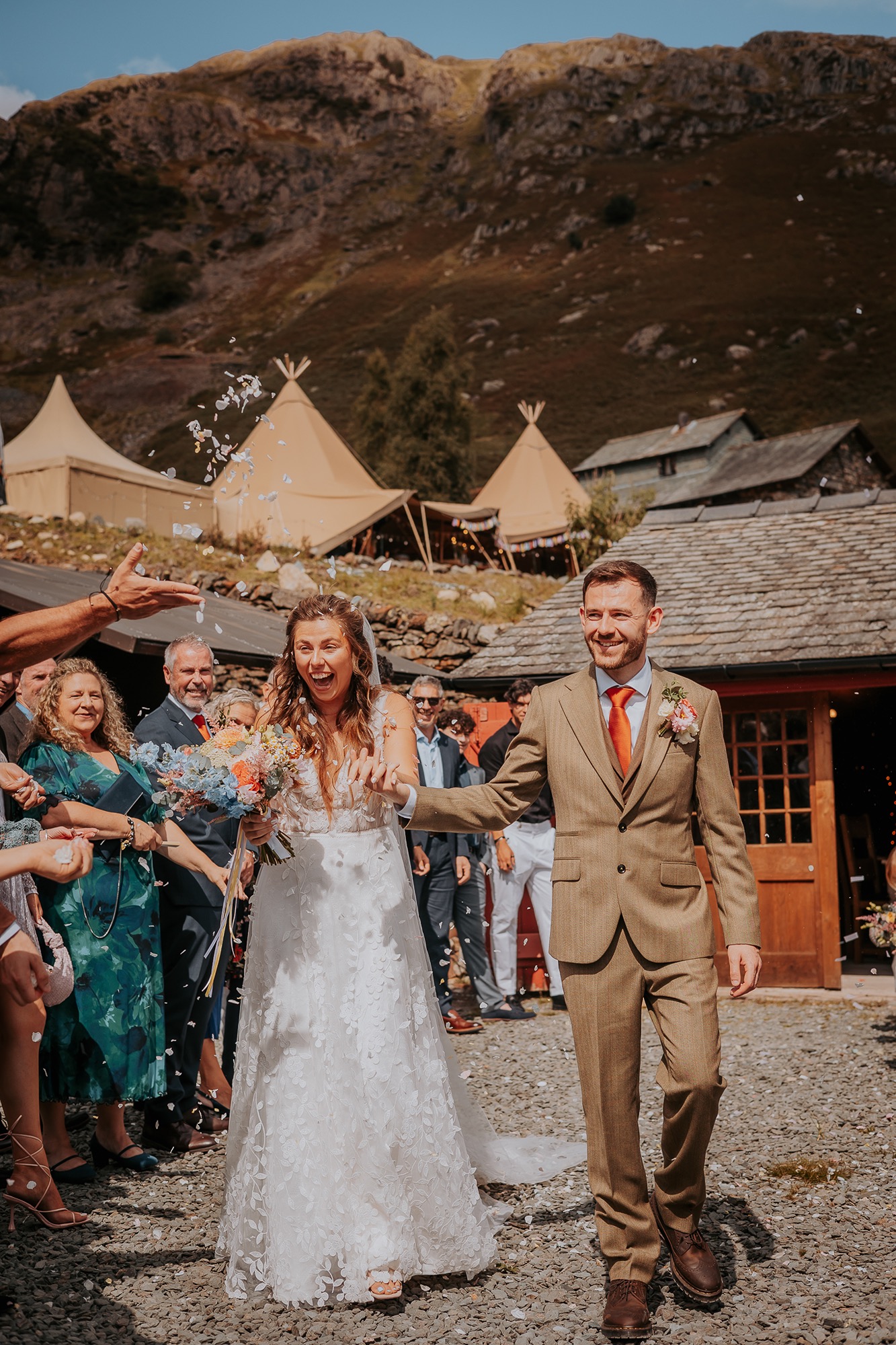 Confetti being thrown over newly weds at Coniston Coppermines with FJell tipi in the background