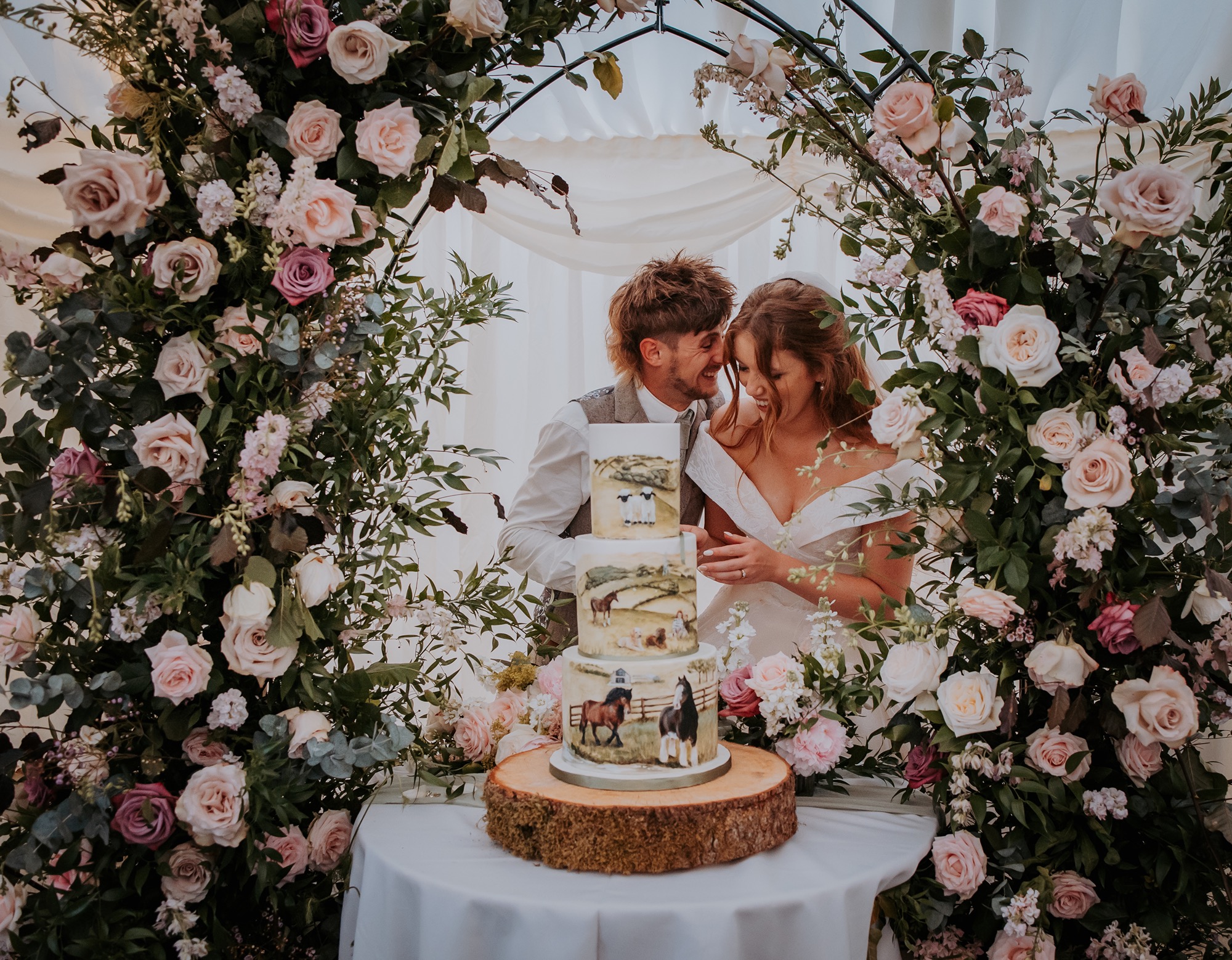 Bride and groom giggle whilst cutting their wedding cake