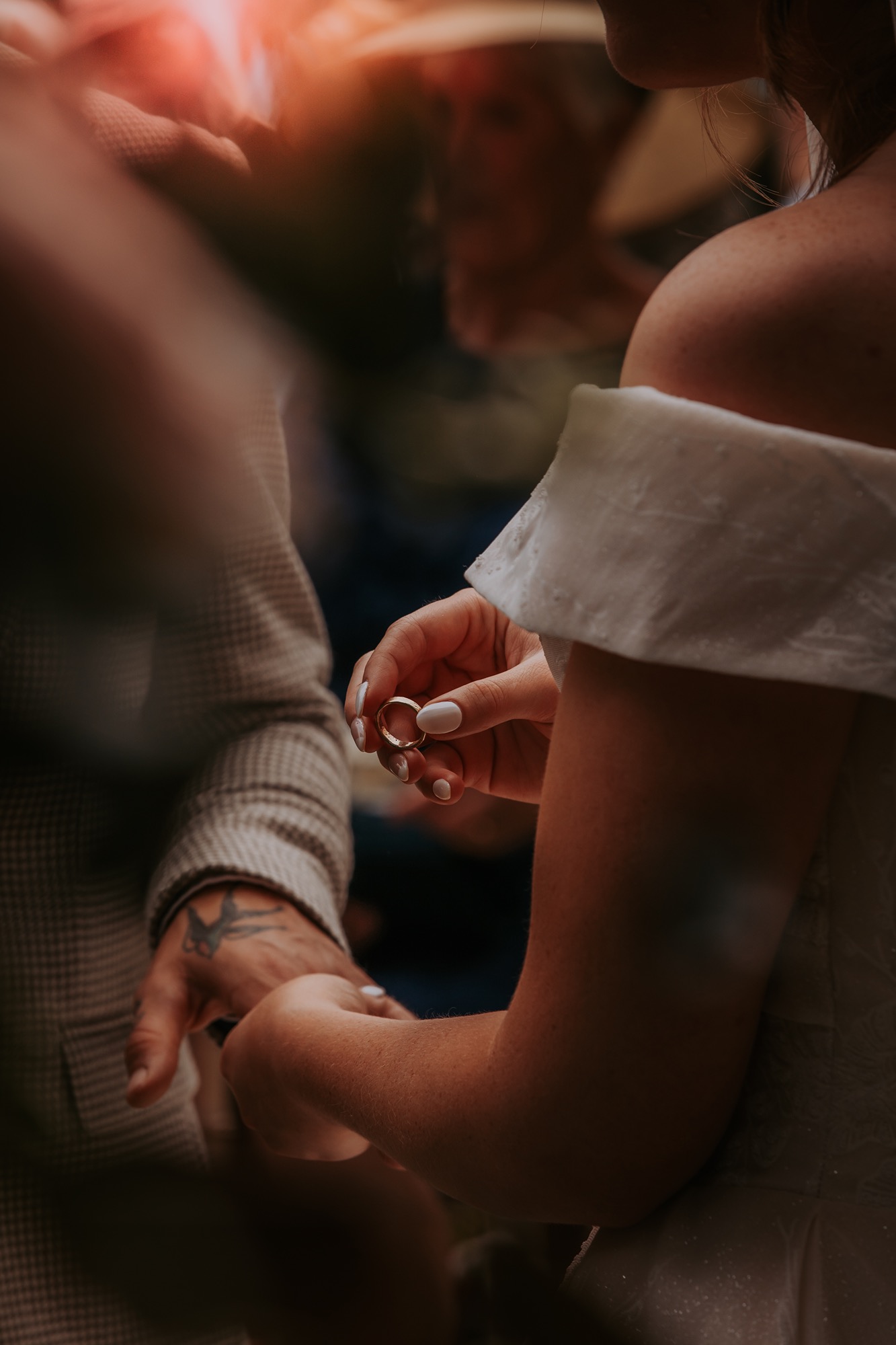 groom receives wedding ring off bride at farm wedding