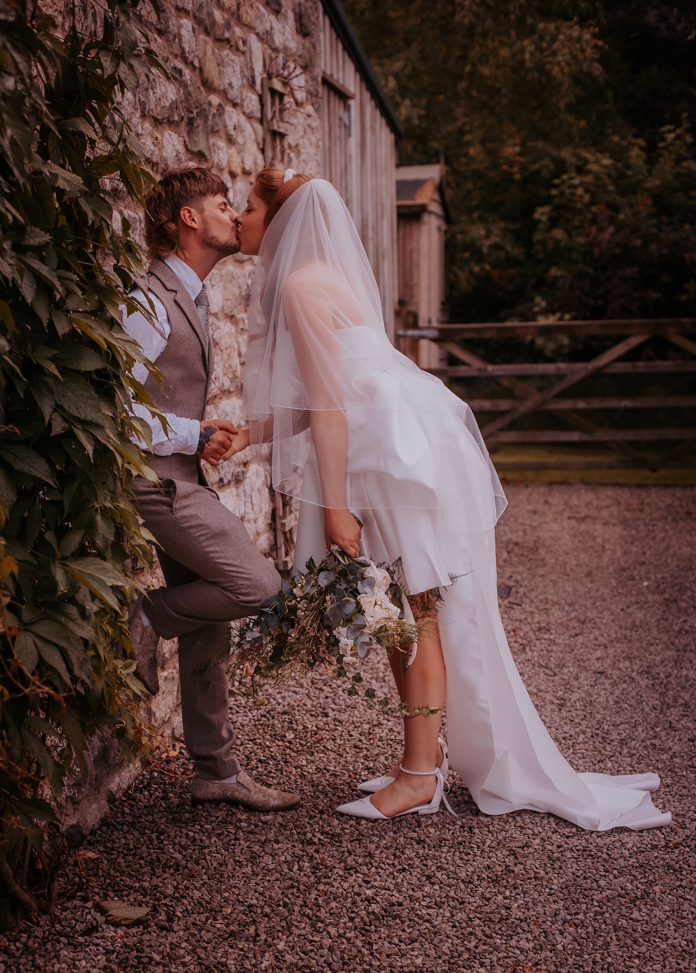 bride and groom kiss, outside farm house