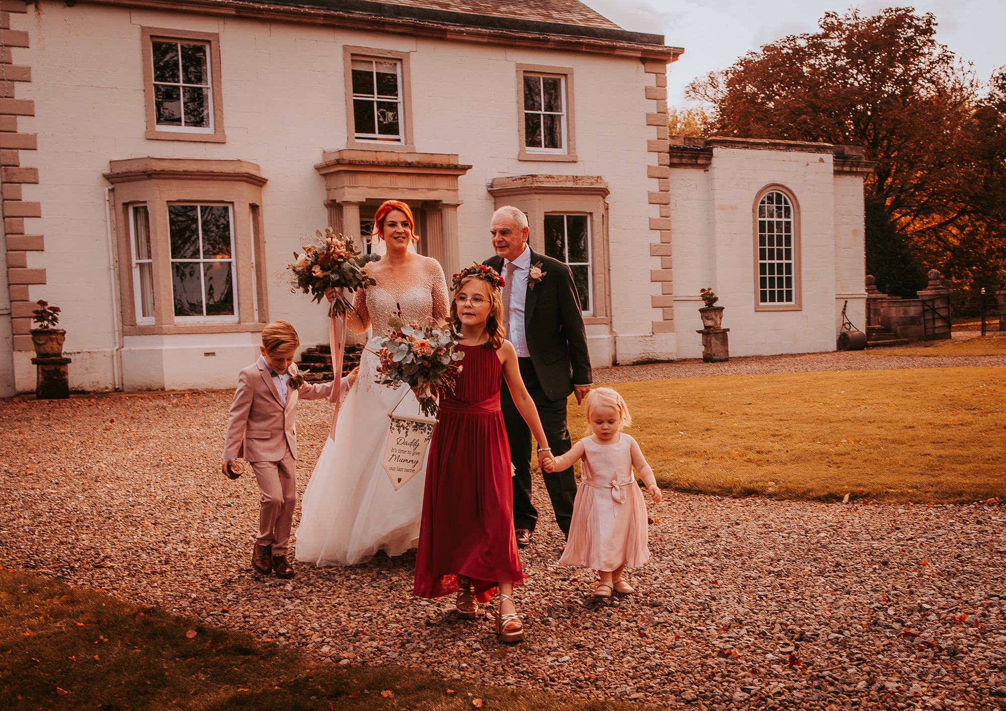 Bridal party walk towards garden ceremony from Holesfoot house, Lake District