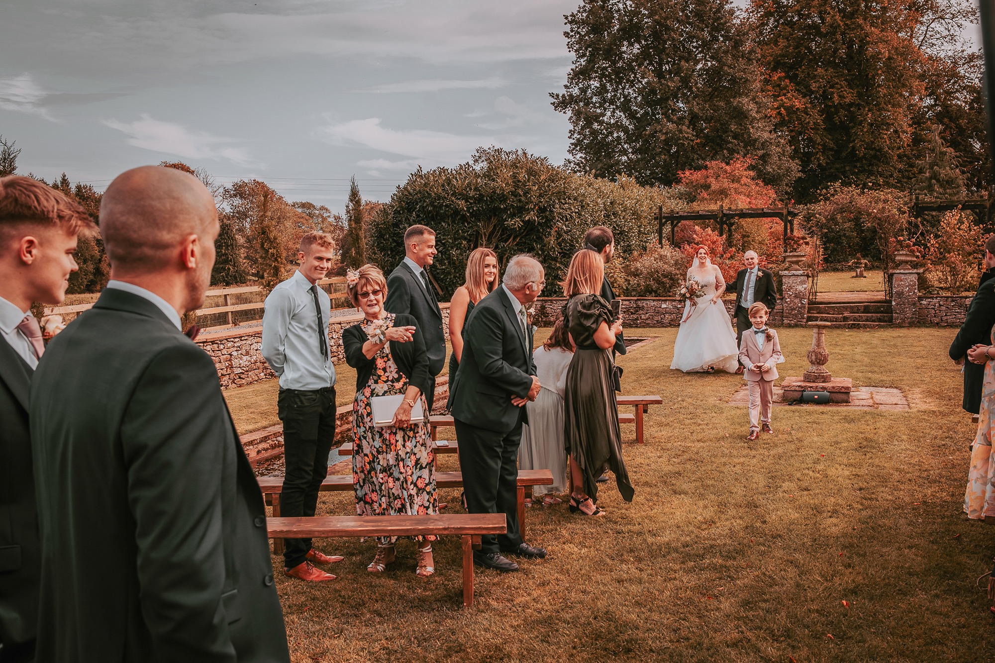 Page boy walking down the aisle in Holesfoot garden wedding ceremony