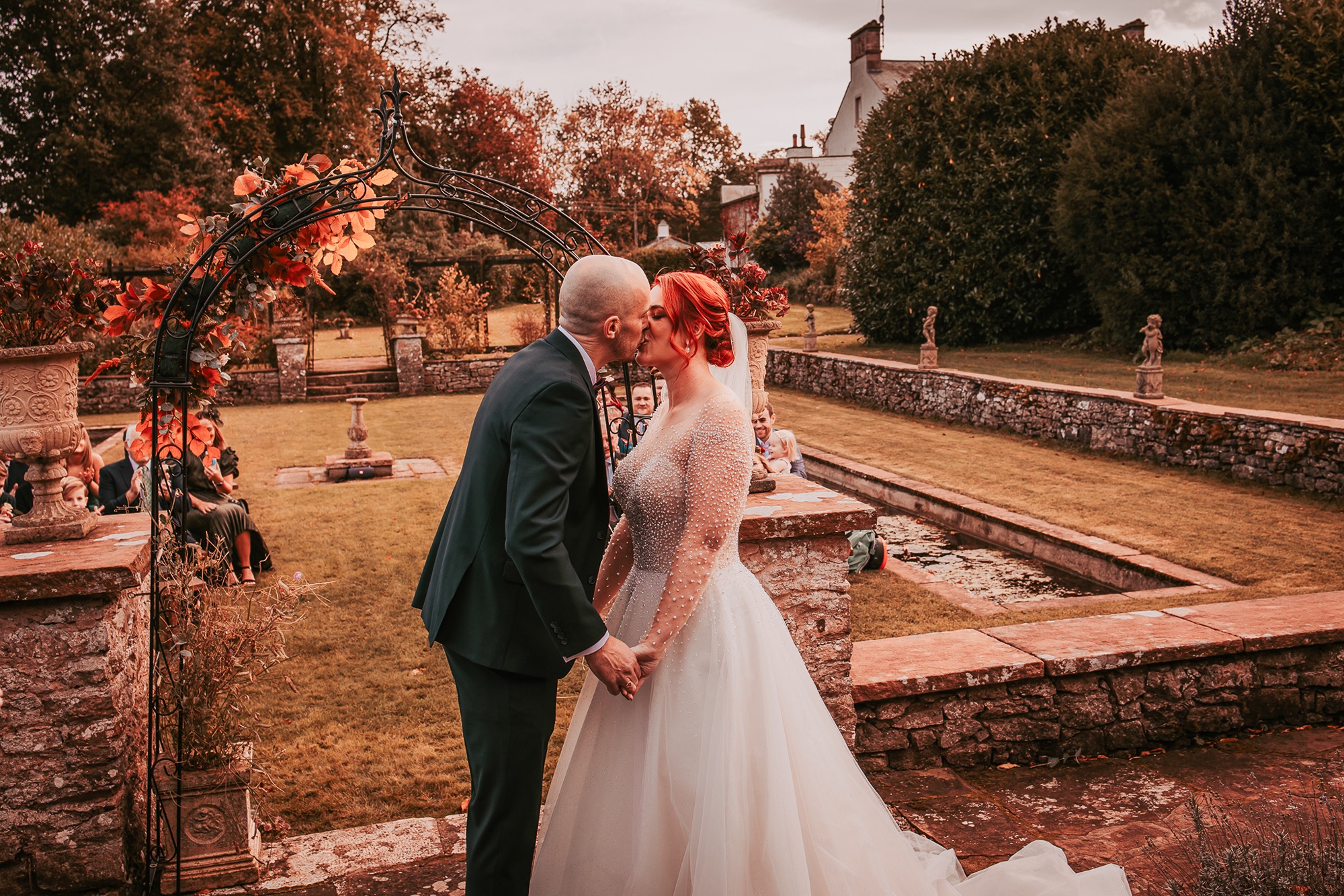 First kiss for bride and groom in the gardens at Holesfoot