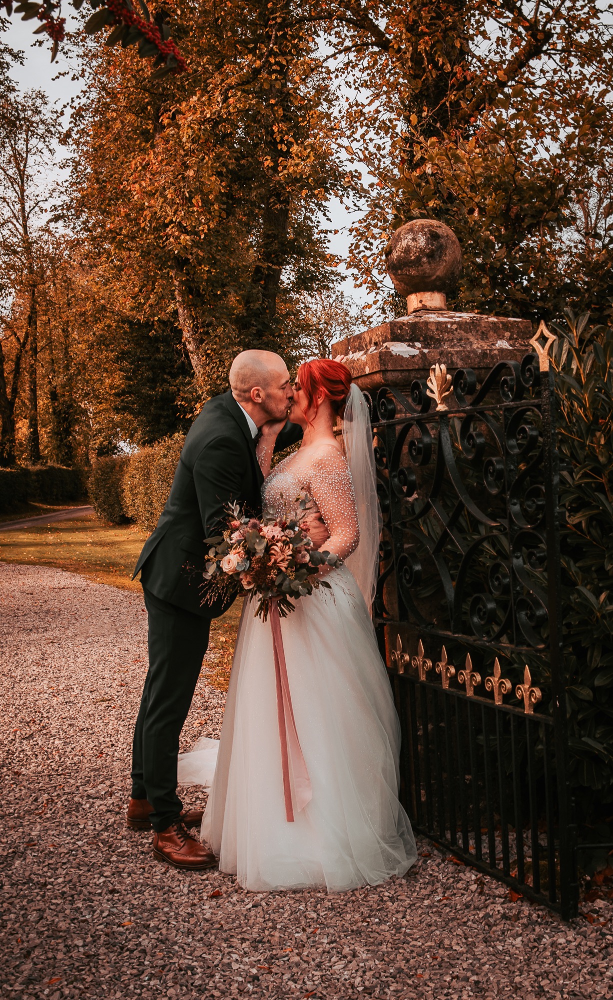 groom kisses bride at entrance gate at Holesfoot, Penrith