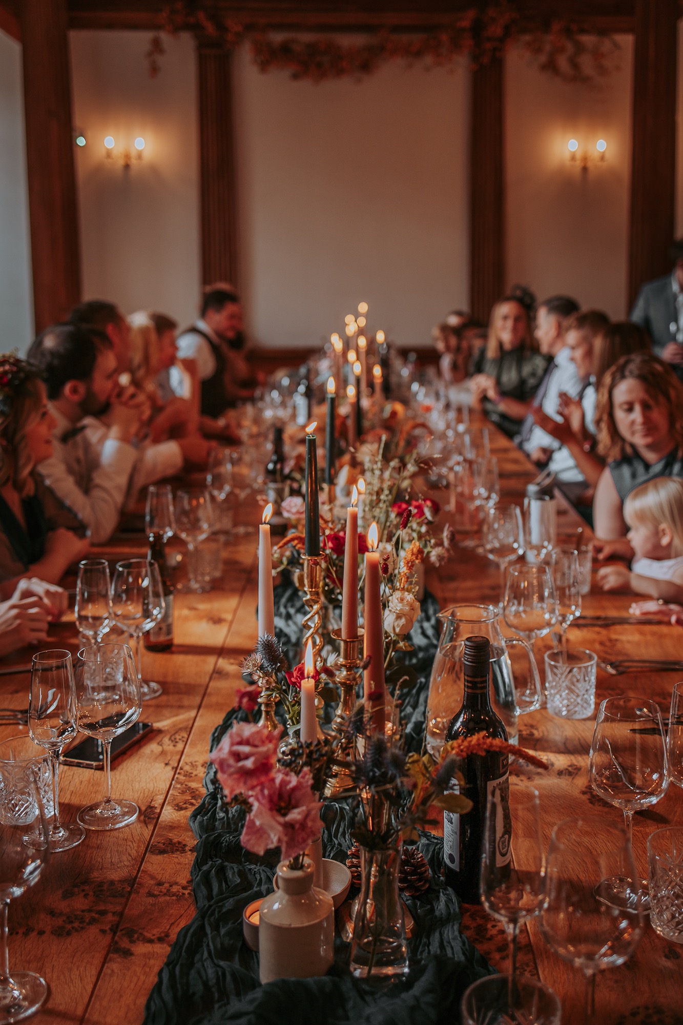 Wedding guests sit around reception table ready to enjoy a roast dinner