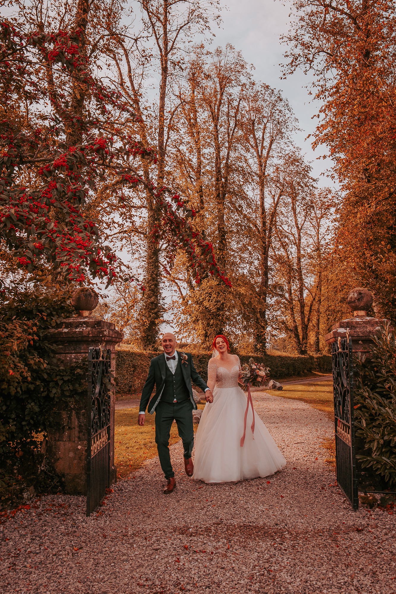Bride and groom walk through entrance gate to Holesfoot hand in hand
