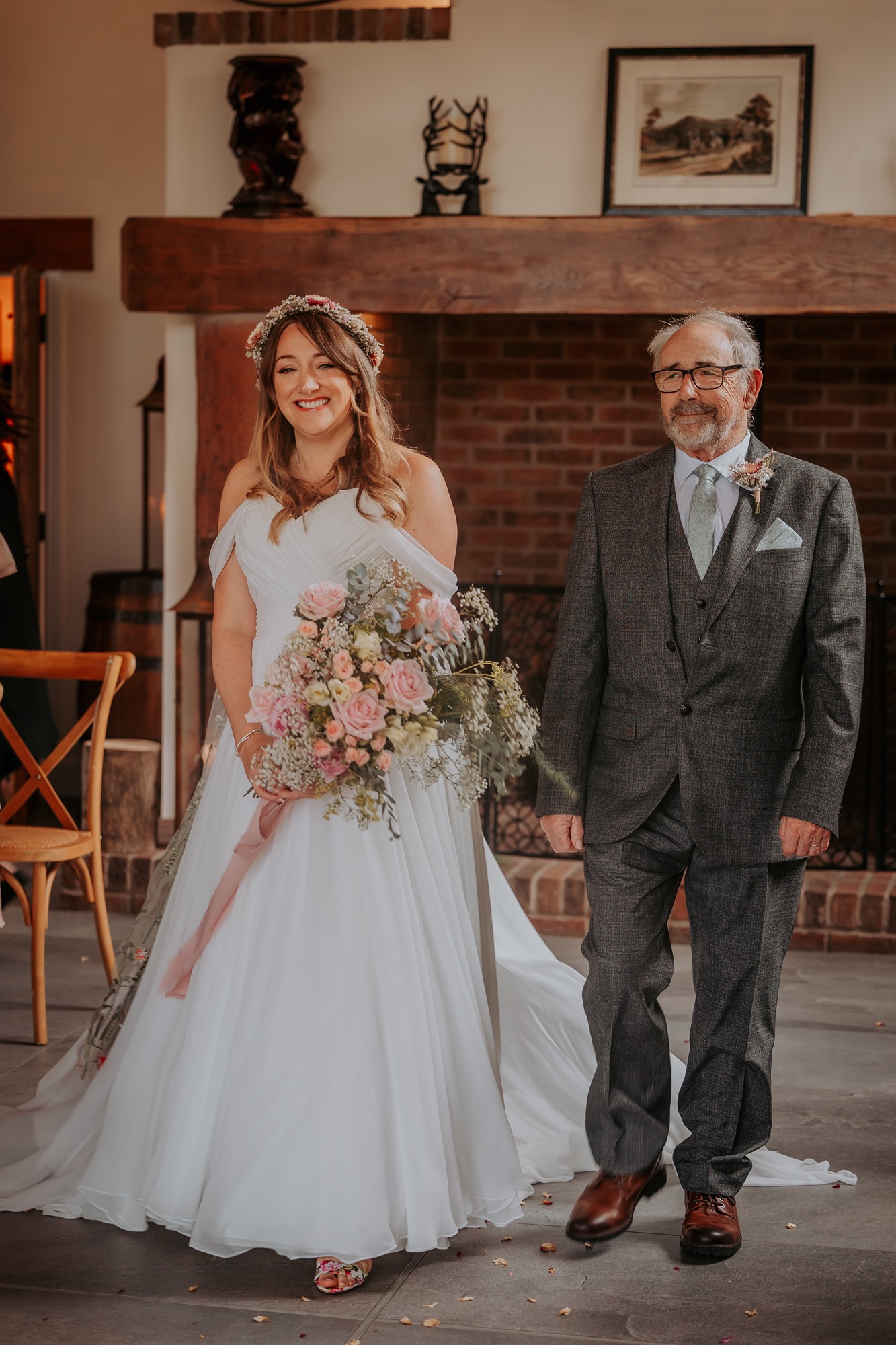 smiling bride walks down the aisle with her father at New House Farm, Cumbria wedding venue