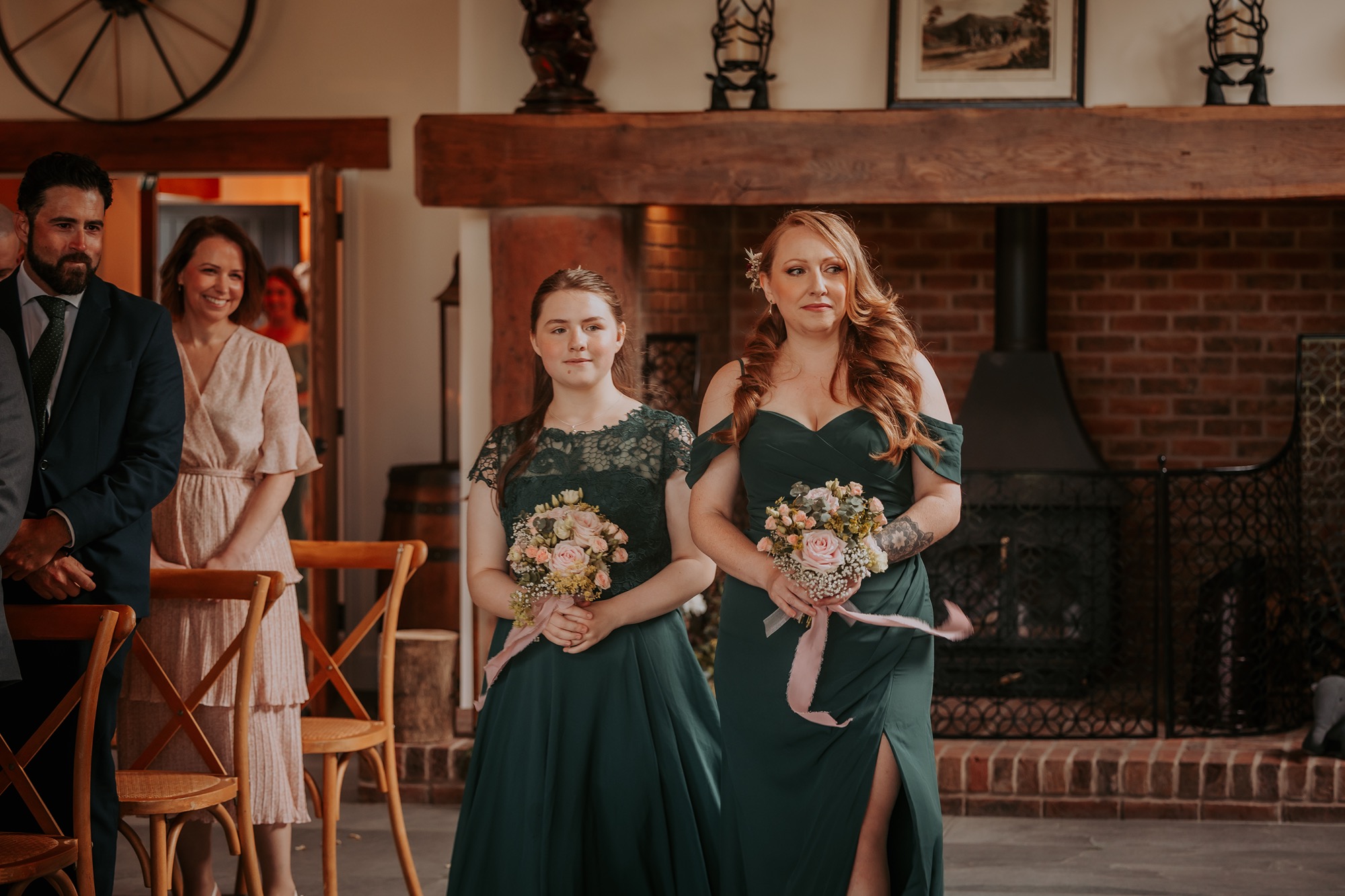 Bridesmaids walk down the aisle in dark green dresses