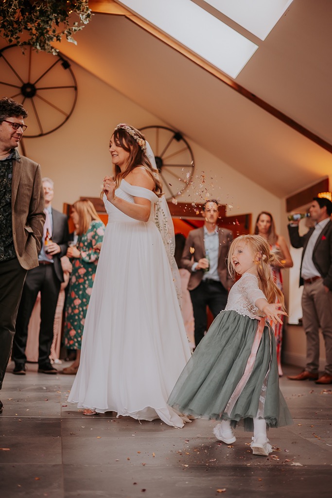 flower girl throwing natural confetti inside at New House Farm