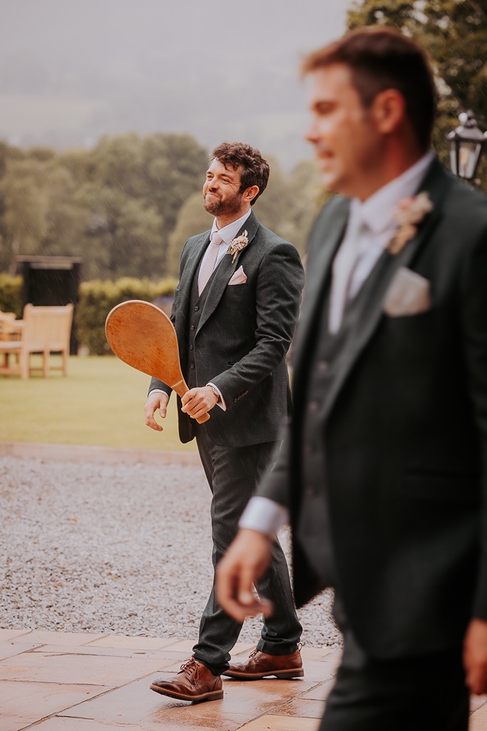 groom playing paddle in New House Farm gardens during wedding day