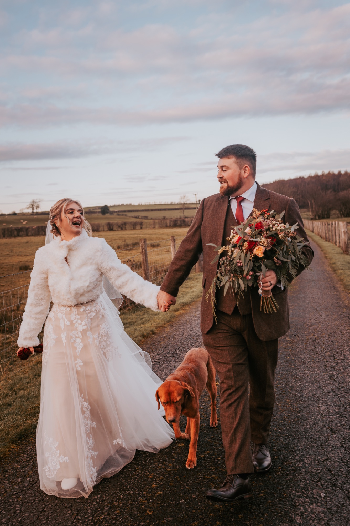 Bride and groom walk their dog at Low Hall the Lakes