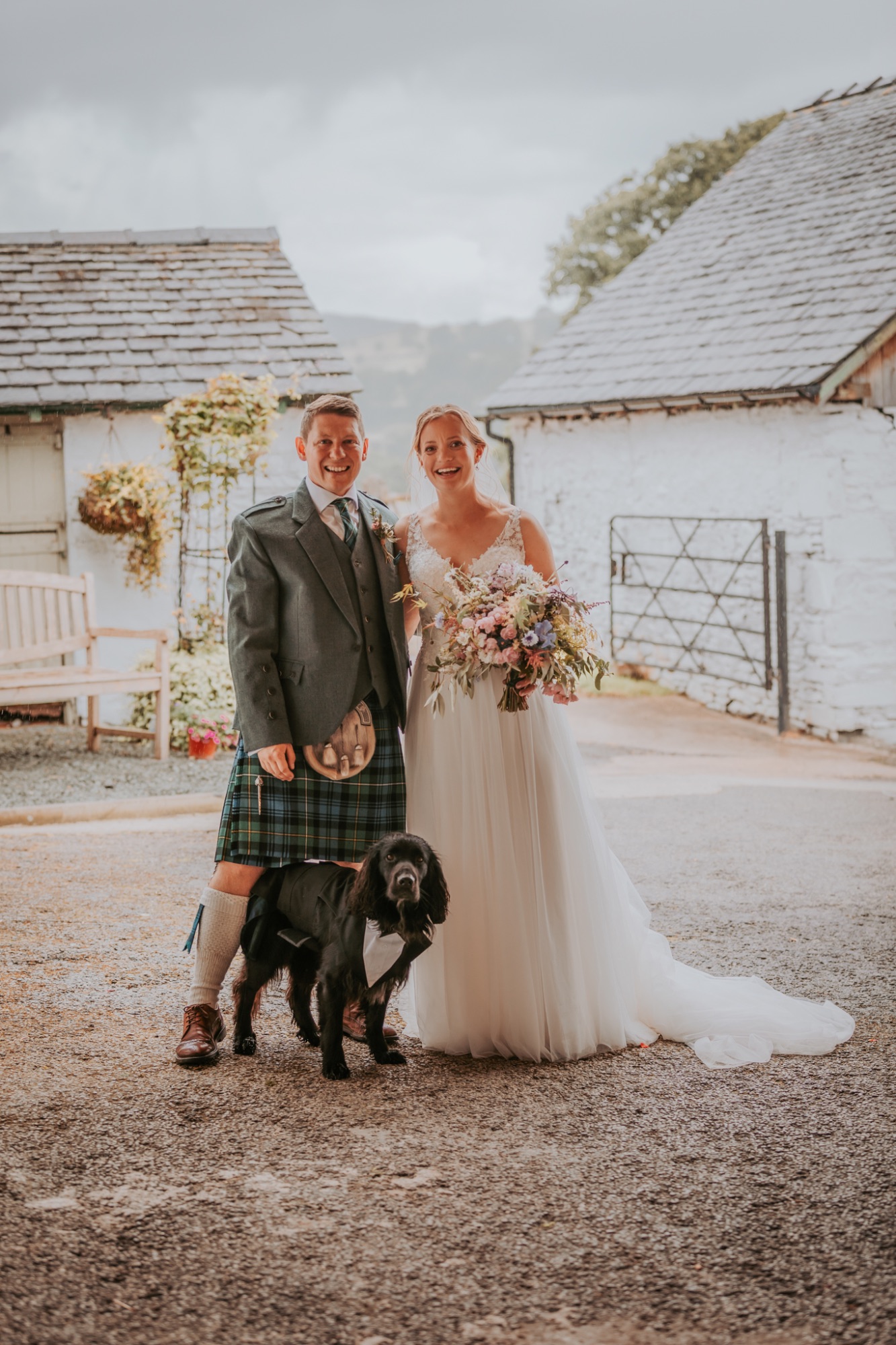 Bride and groom pose with their dog at Fairbank wedding barn