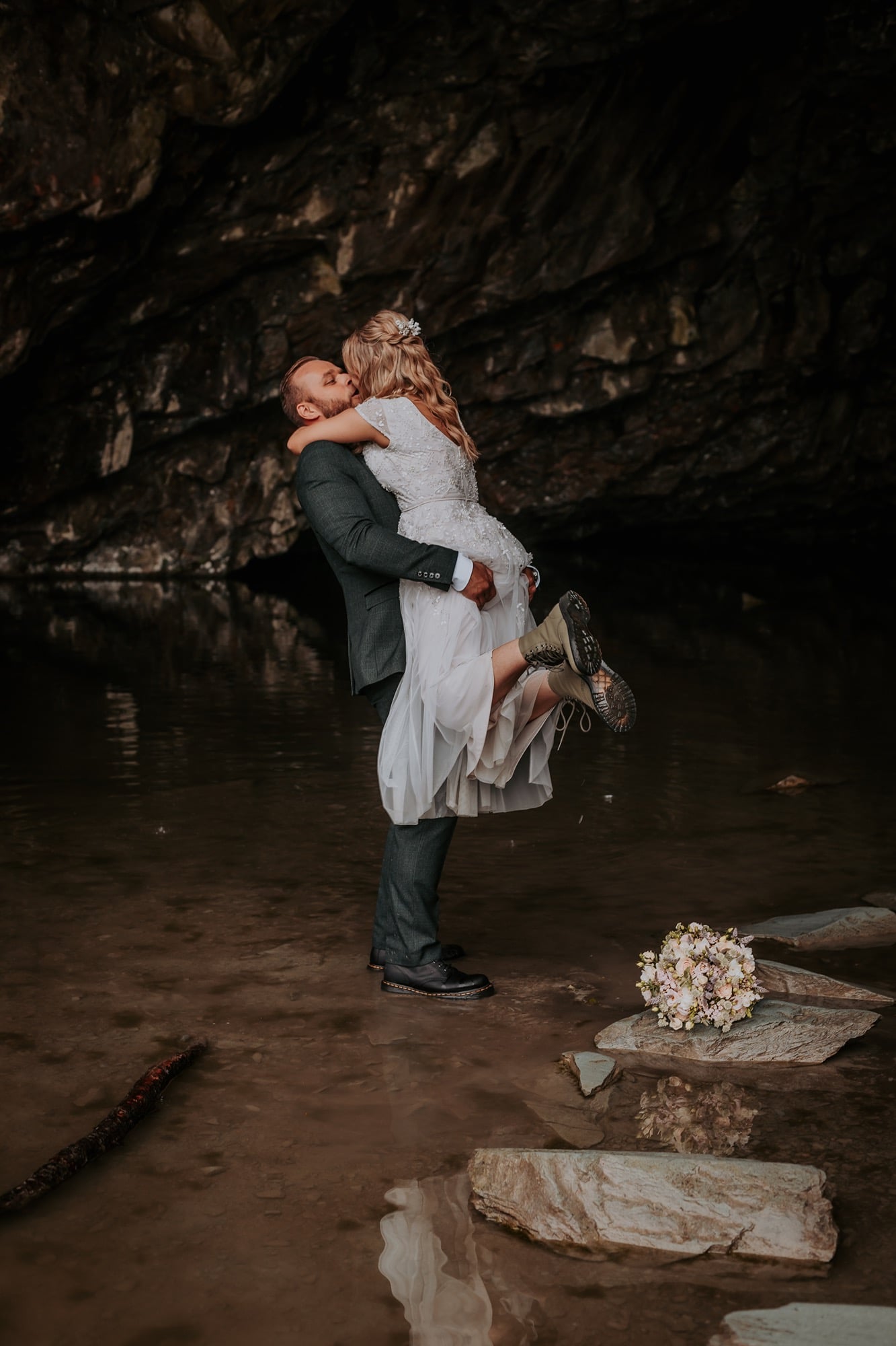 Groom lifts bride in Rydal cave as they celebrate their wedding in the heart of the Lake District