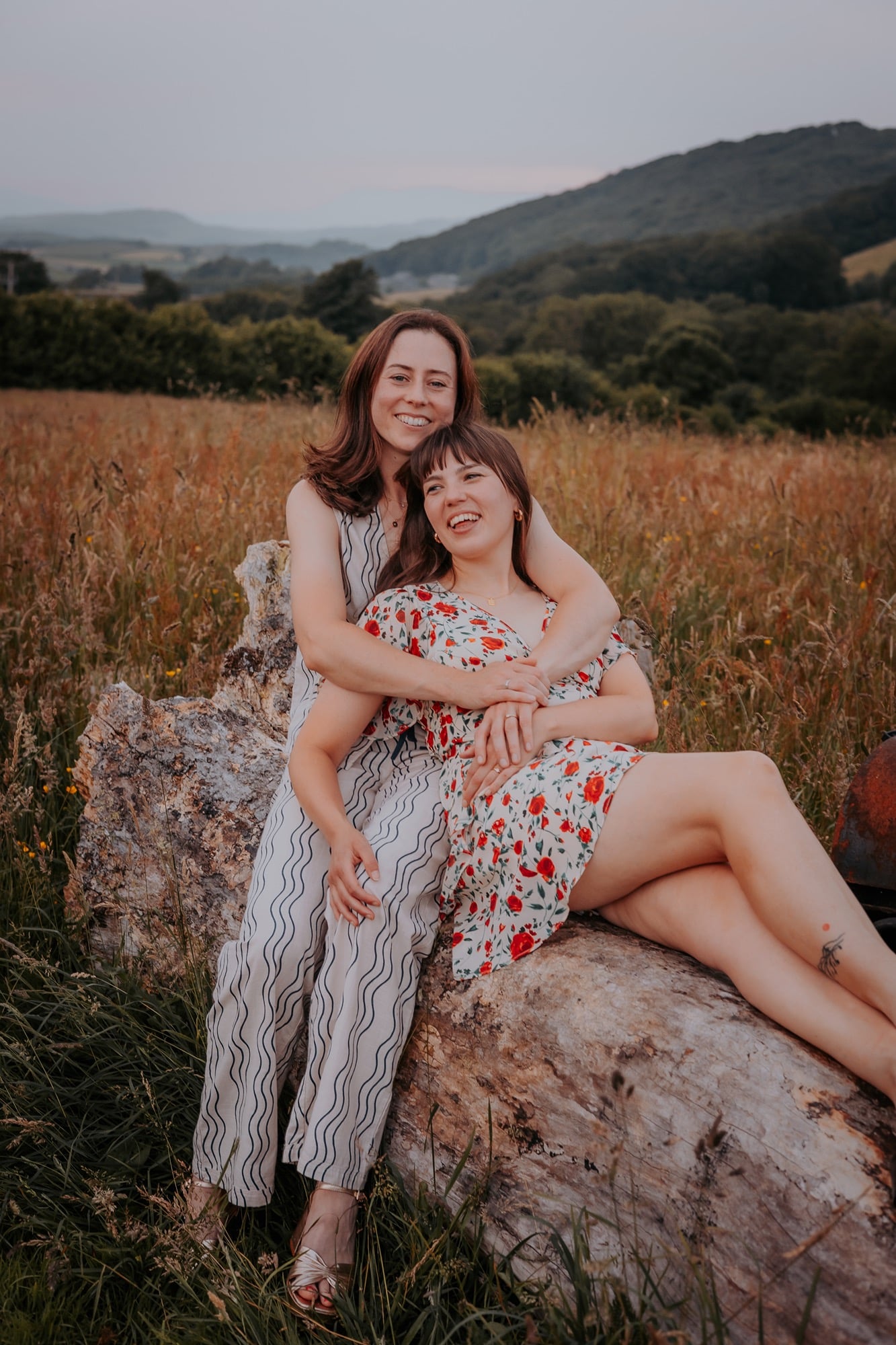 Same sex couple cuddle on portrait session in The Lake District